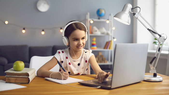 elearning provider in UK and Worldwide young girl in white headphones smiling watching a webinar on a laptop