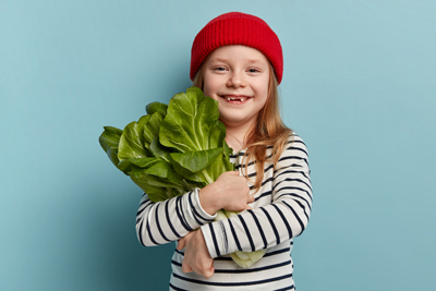 elearning provider in UK and Worldwide girl in red hat hugging large lettuce to show sustainability